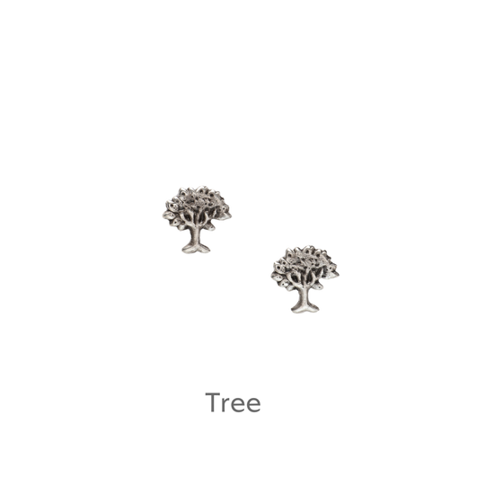 a pair of silver tree earrings on a black background