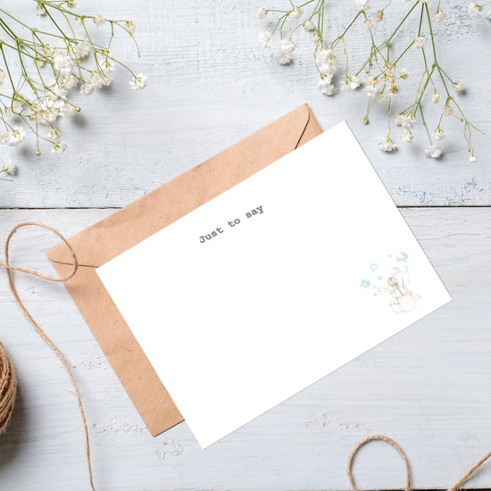 a white card with a brown envelope on a white table