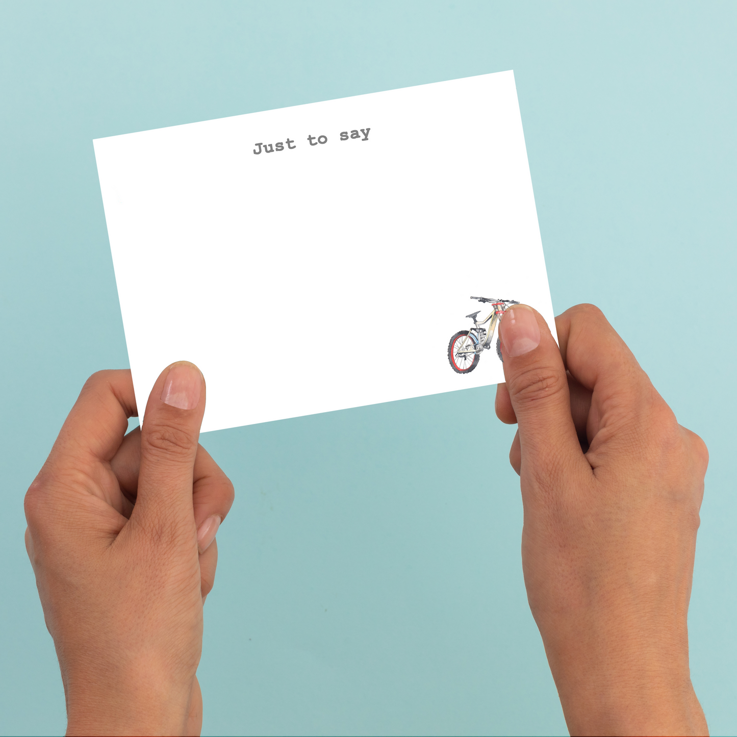 a person holding a piece of paper with a bike on it