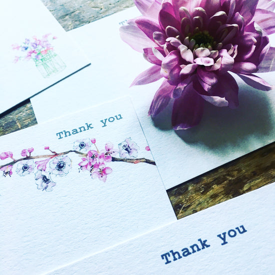 a purple flower sitting on top of a wooden table