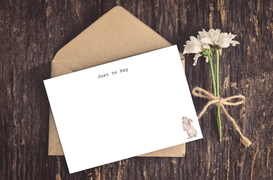 a card with a bird on it next to a flower