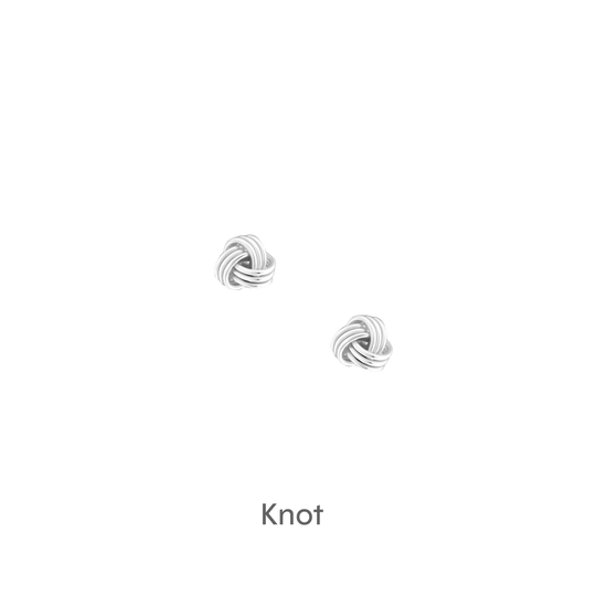 a pair of silver earrings on a black background