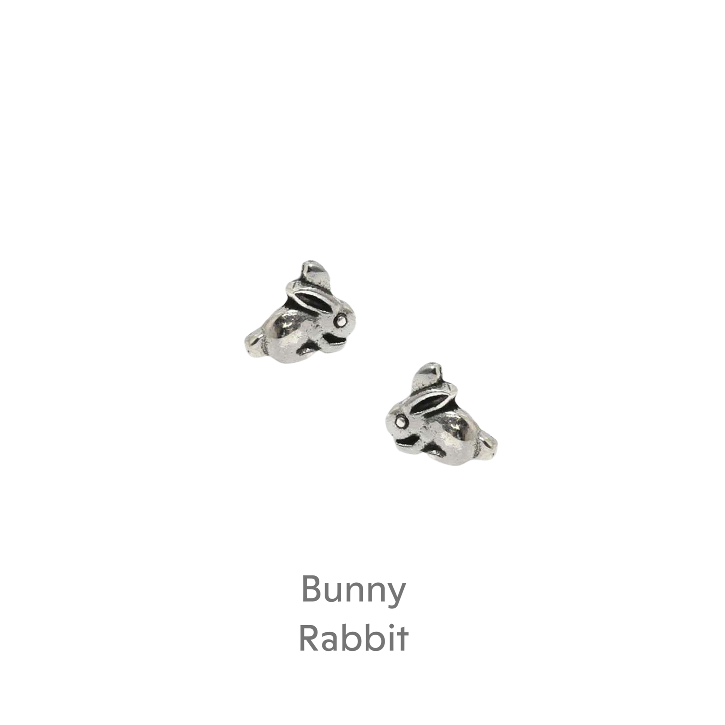 a pair of silver earrings on a black background