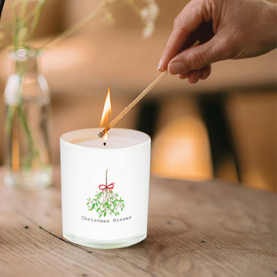 a person lighting a candle on a table